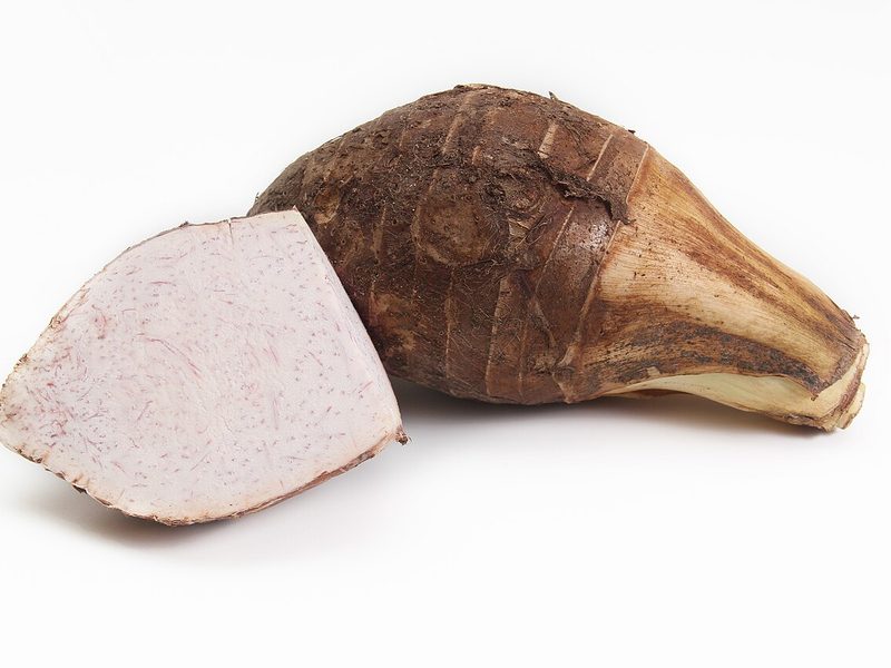 A whole madumbe (taro) corm beside a cut piece showing the pale flesh (example photo)
